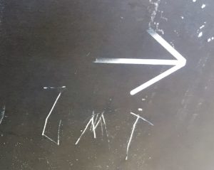 At one train intersection someone scratched on the back of an other sign, "JMT" and an arrow pointing to the right.
